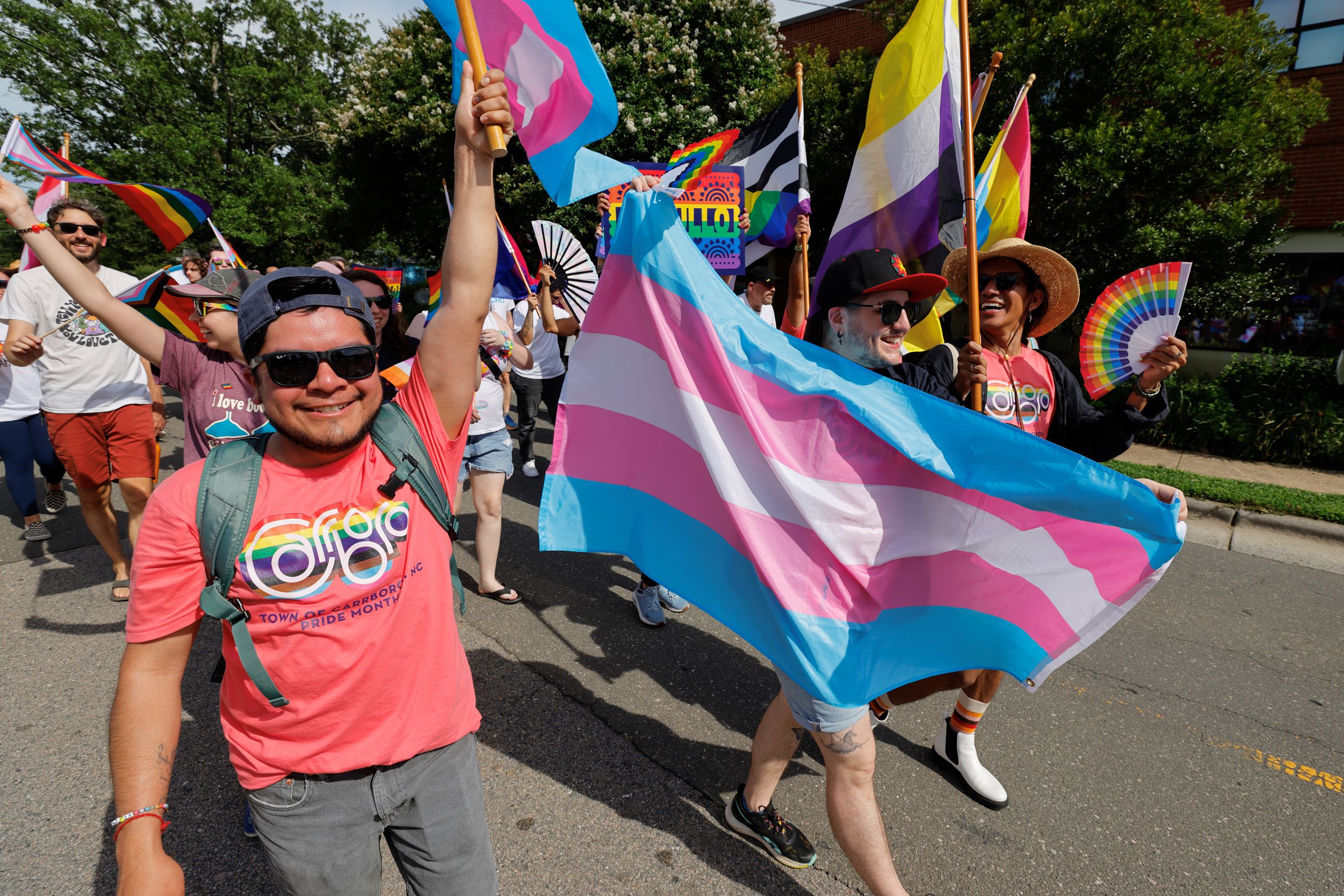 Community members waving the Transgender Flag and wearing Carrboro Pride t-shirts